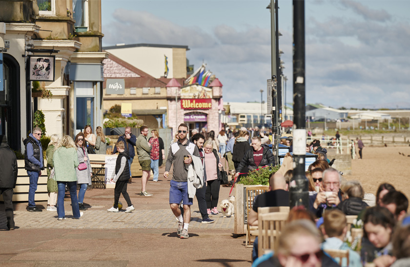 The promenade at Portobello Beach, filled with people enjoying the sunshine