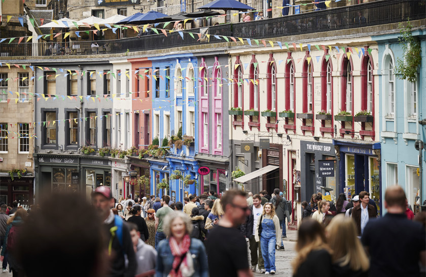 The iconic blue, pink, cream, orange, and other colourful buildings of Edinburgh's Victoria Street leading down to the Grassmarket area.