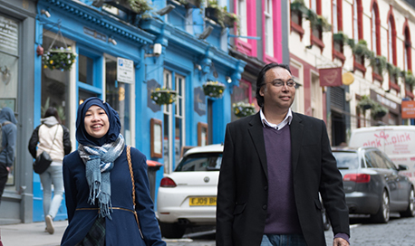 Pedestrians walking down Victoria Street with its brightly painted buildings, Edinburgh