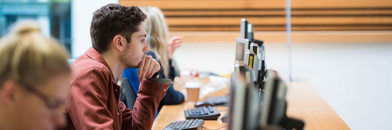 QMU student working at computer in Atrium