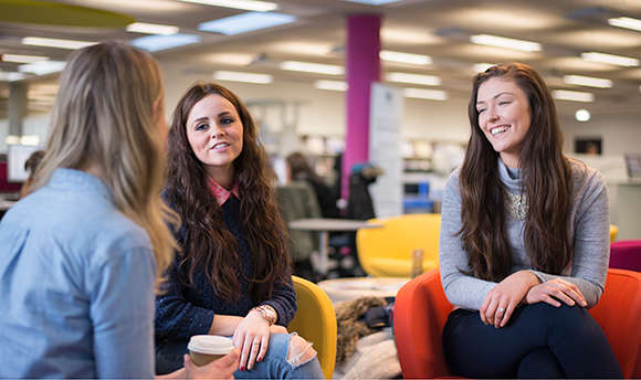 Group of students smiling and talking together, QMU campus, Edinburgh