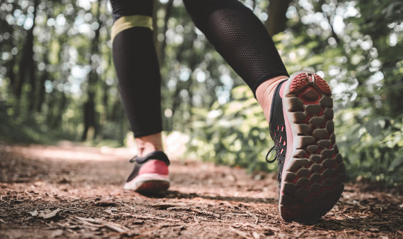 A woman walking on a woodland trail