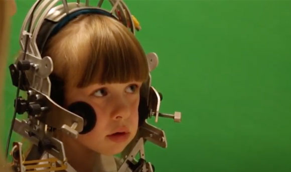 A young boy wearing a speech measurement device