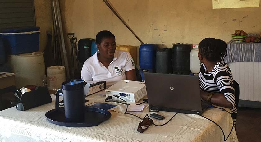 Two women working on a laptop and talking together