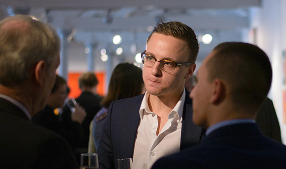 A young man networking with professionals at Dovecot Studio, Edinburgh