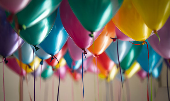 Close up of a bunch of multicoloured balloons full of helium