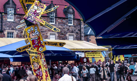 A sign in the crowded Pleasance square during the Edinburgh Festival Fringe