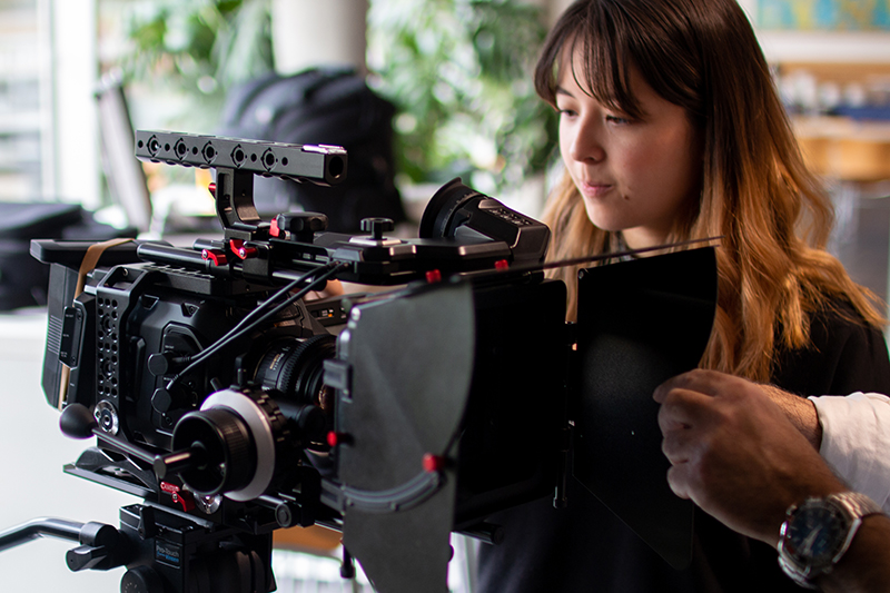 QMU film student standing beside a high end camera