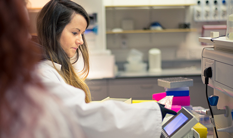 Two students in a laboratory wearing lab coats