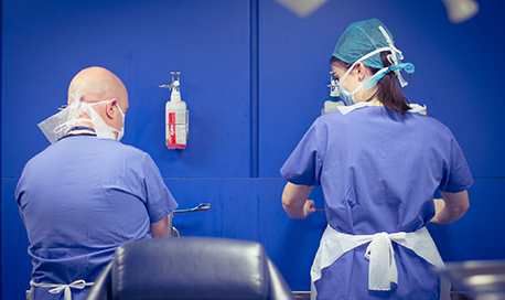 two Podiatry students wearing PPE and washing their hands