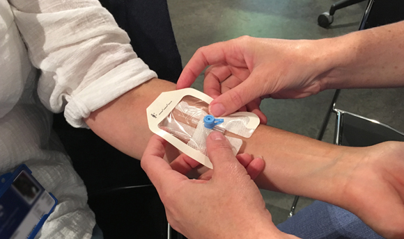 A student nurse fitting a cannula to a patient's arm