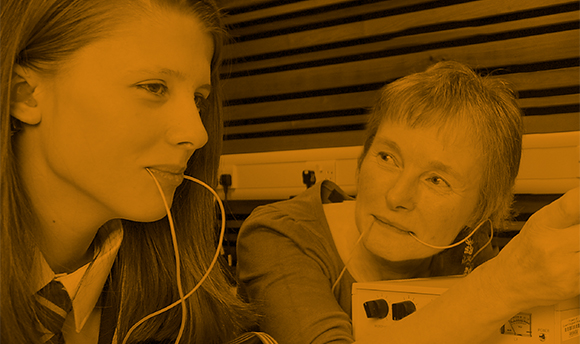 A young girl using the speech and language therapy equipment with a woman