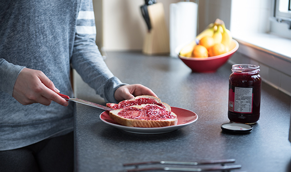 Close up of jam being spread onto toast