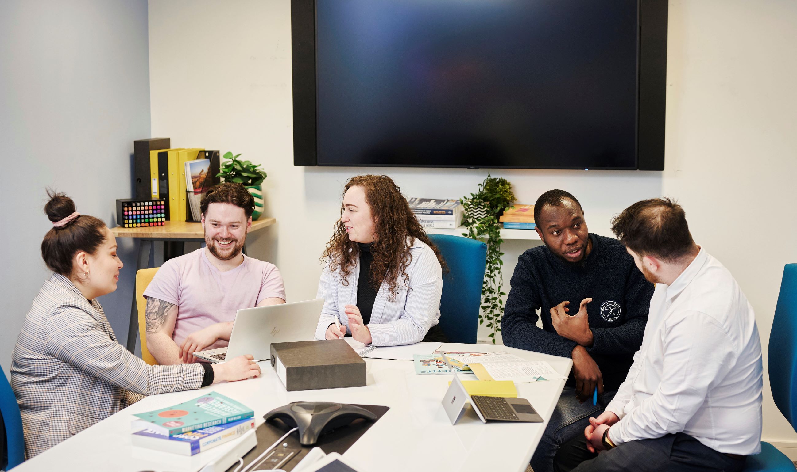 Group of business people sitting around a desk chatting