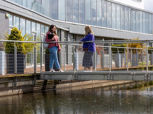 Image of students having a conversation on the bridge at QMU