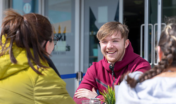 QMU Student Relaxing Outside