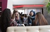 A group of students sit talking and laughing on sofas, Queen Margaret University, Edinburgh